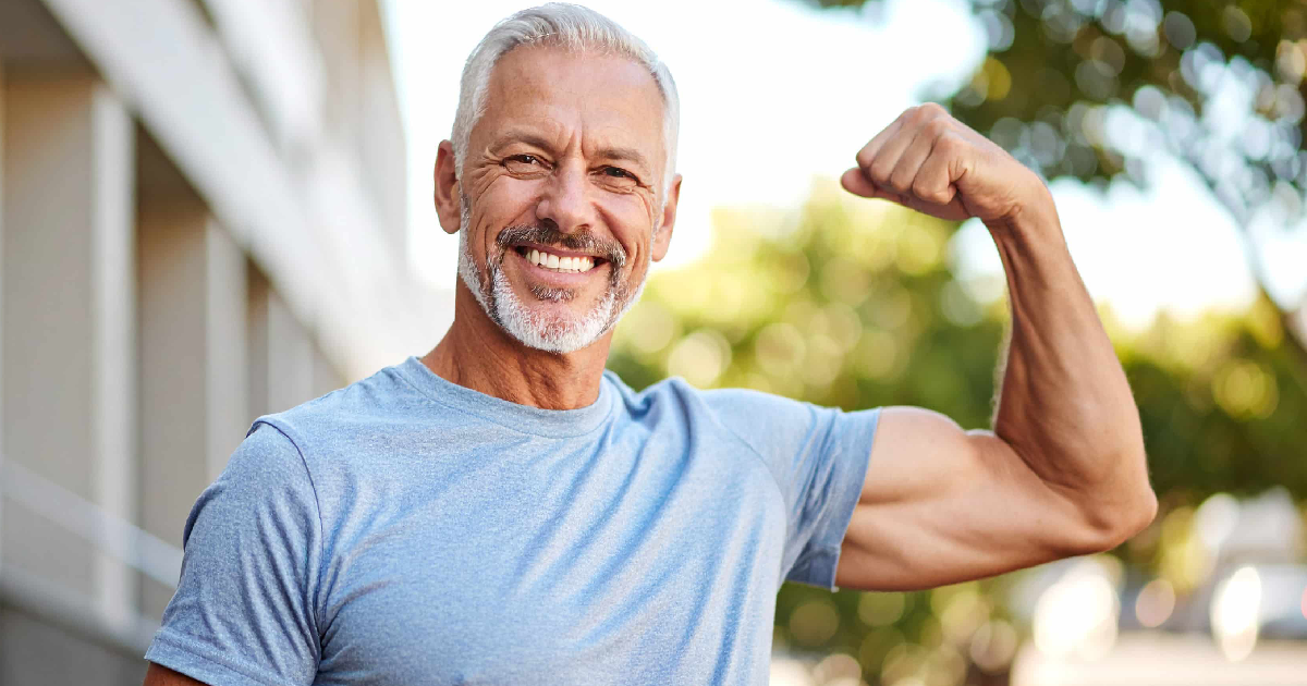 Man showing biceps with a happy expression, showing enhanced muscle growth after Testosterone Optimization in Derby, KS.