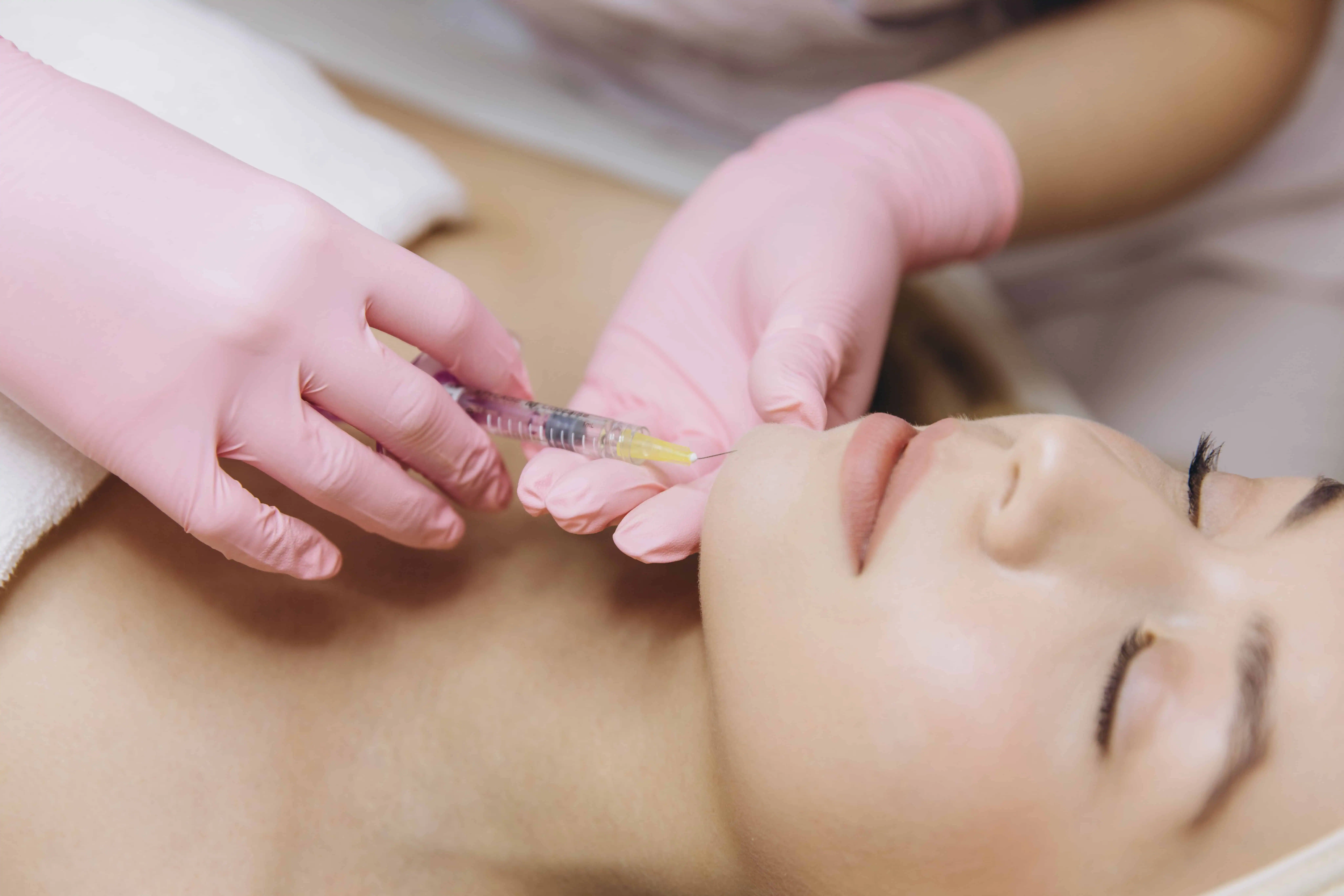 Clinician injecting Xeomin neurotoxin in a woman's chin at Enhanced Wellness in Derby, KS.